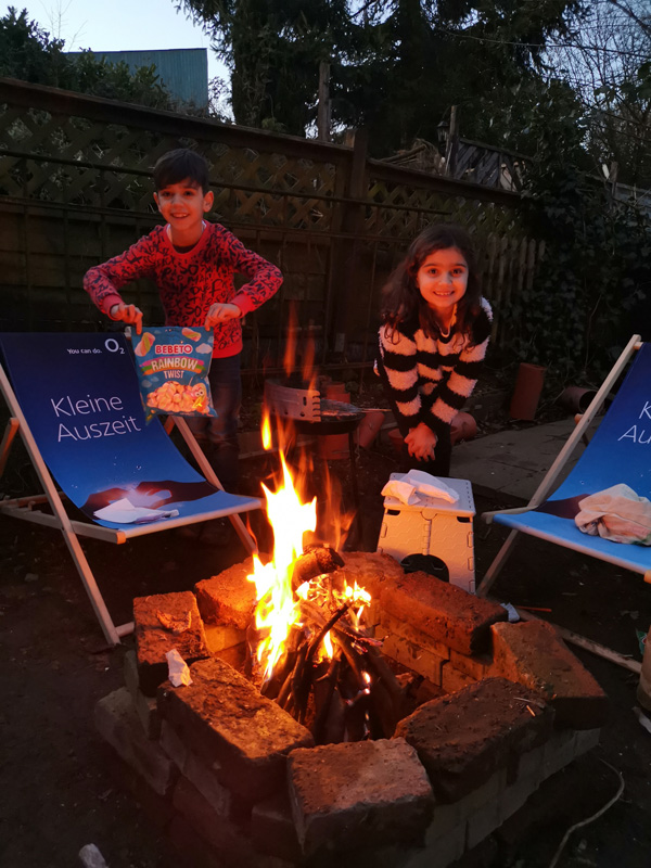 Eda und Emirhan braten Marshmallows über dem Lagerfeuer